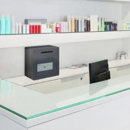 Coffre de dépôt Chubbsafes Sigma Deposit posé derrière le comptoir d’un commerce (mise en situation)